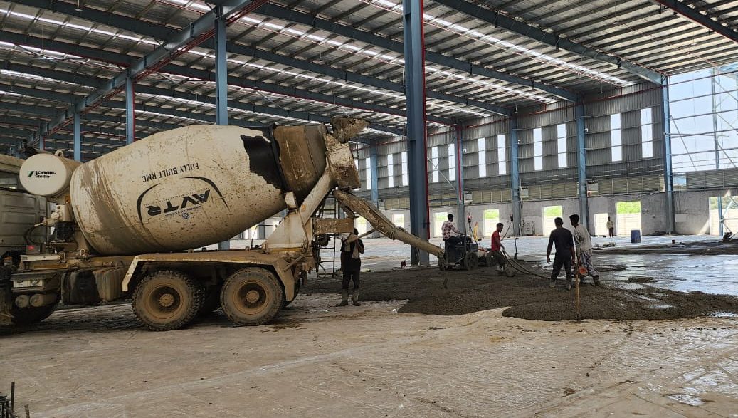 Industrial factory construction with ready-mix concrete flooring work in progress by Arpit Constructions”